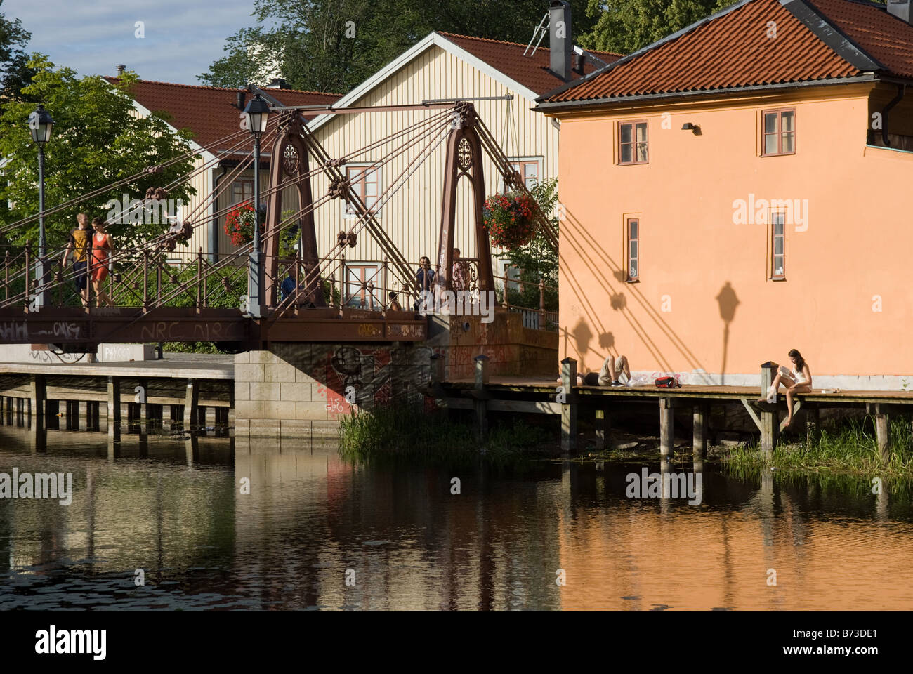 People enjoying the sunshine next to the River Fyris, Uppsala, Sweden Stock Photo
