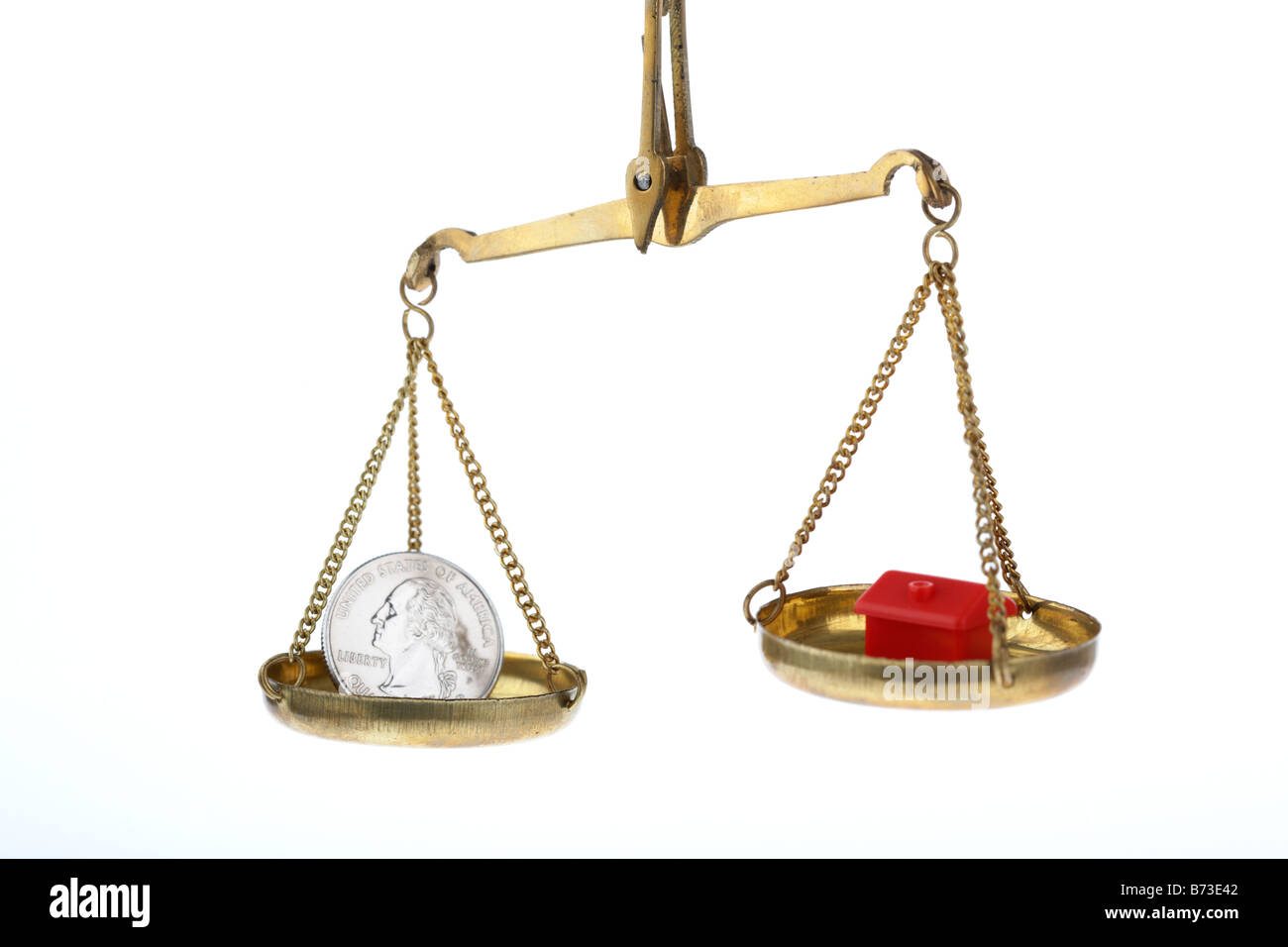 toy red house and one us quarter dollar 25c coin on balancing scales house higher concept us commercial property market and home loan rates Stock Photo