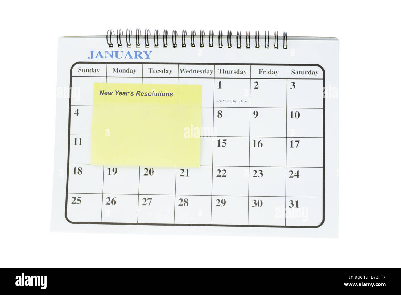 Yellow note sticker on January page of desktop calendar as reminder of New Year s resolutions Stock Photo