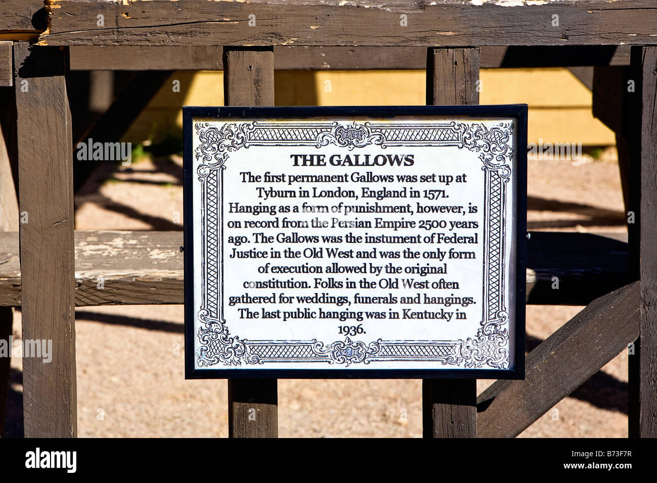 Image of the sign that explains the history of the Gallows and hanging practices in the old west as it hangs today in Old Tucson Stock Photo