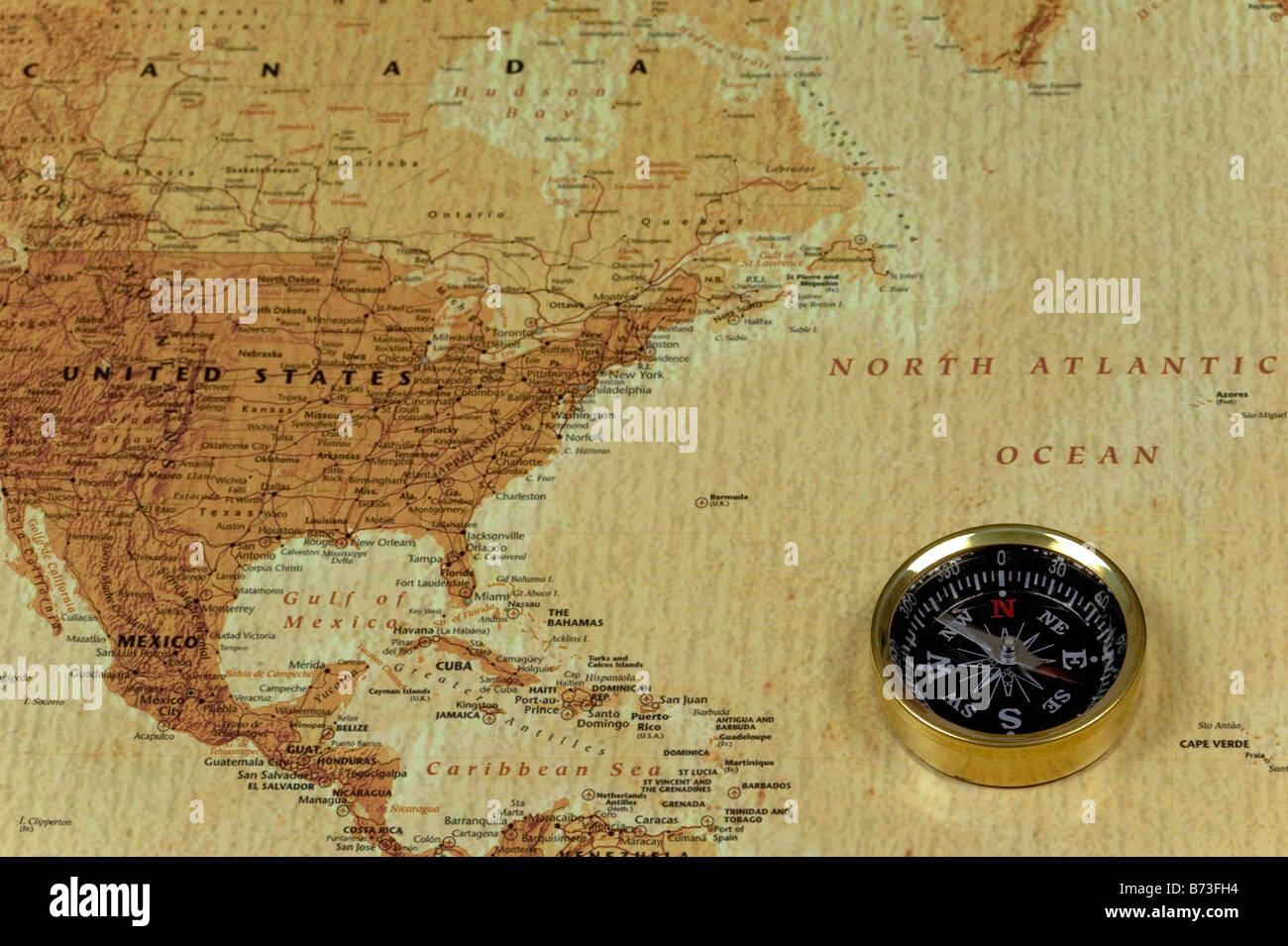 A brss compass on an old map showing the North Atlantic ocean and the United States of America Stock Photo