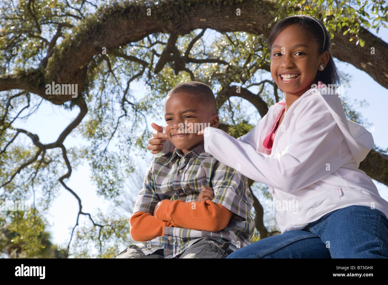 Young African American children outdoors sitting in park Stock Photo ...