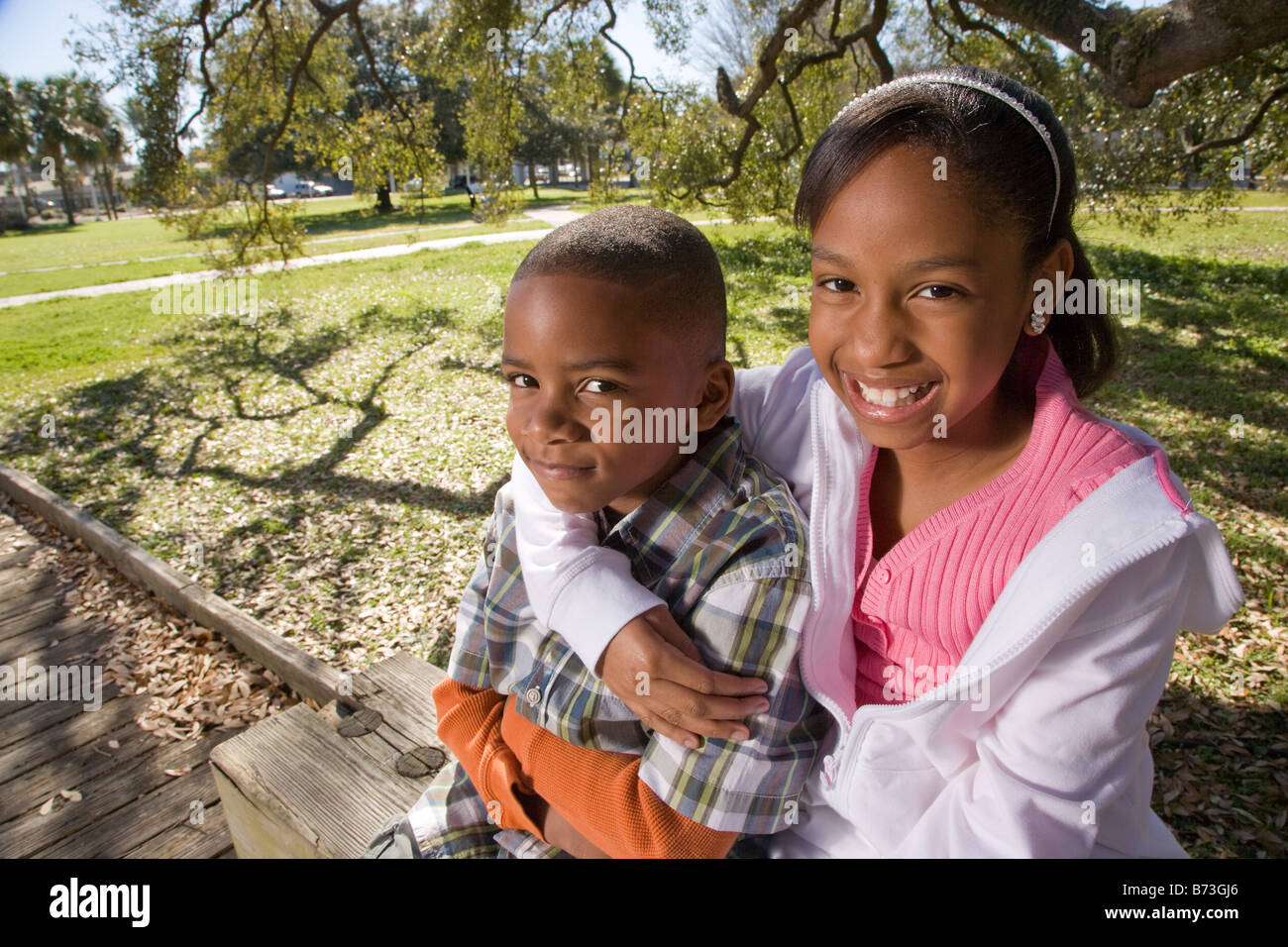 Young African American children outdoors sitting in park Stock Photo ...