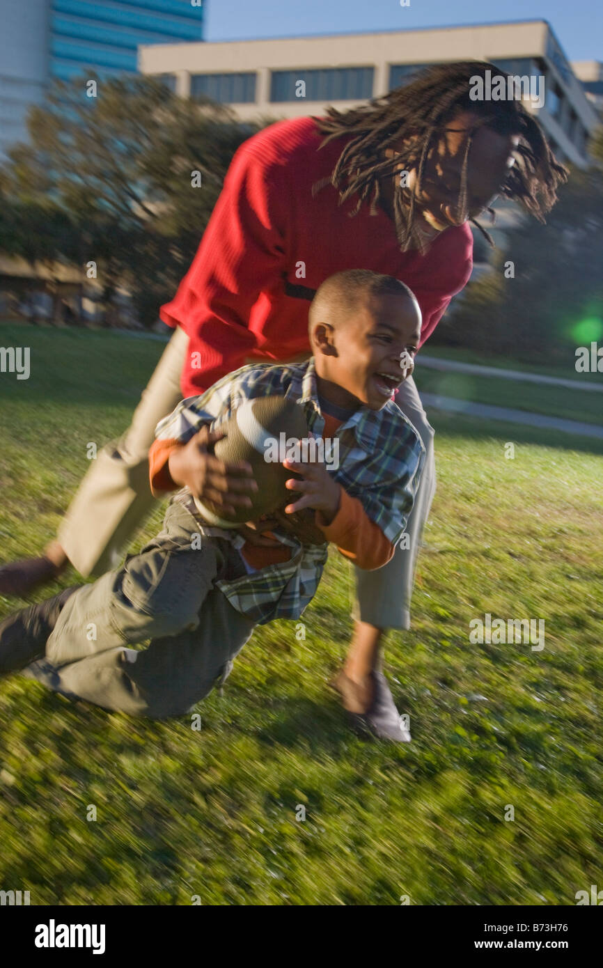 African American father and son playing football Stock Photo - Alamy