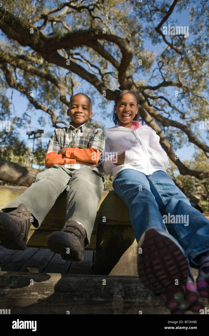 Young African American boy and girl outdoors sitting in park Stock ...