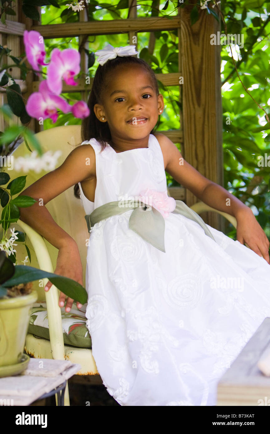 Portrait of cute African American girl sitting on outdoor patio Stock ...