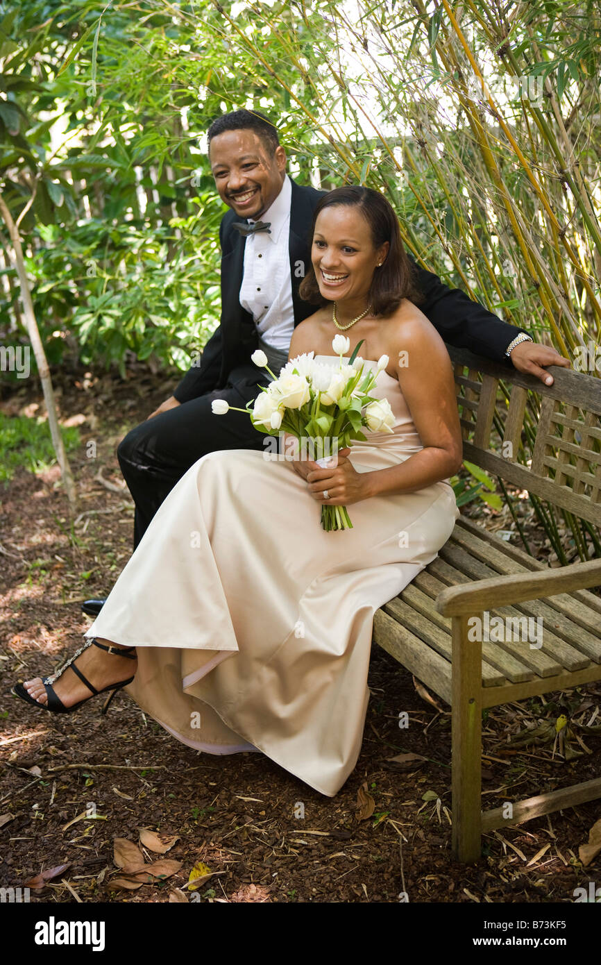 Happy African-American bride and groom sitting on bench Stock Photo - Alamy