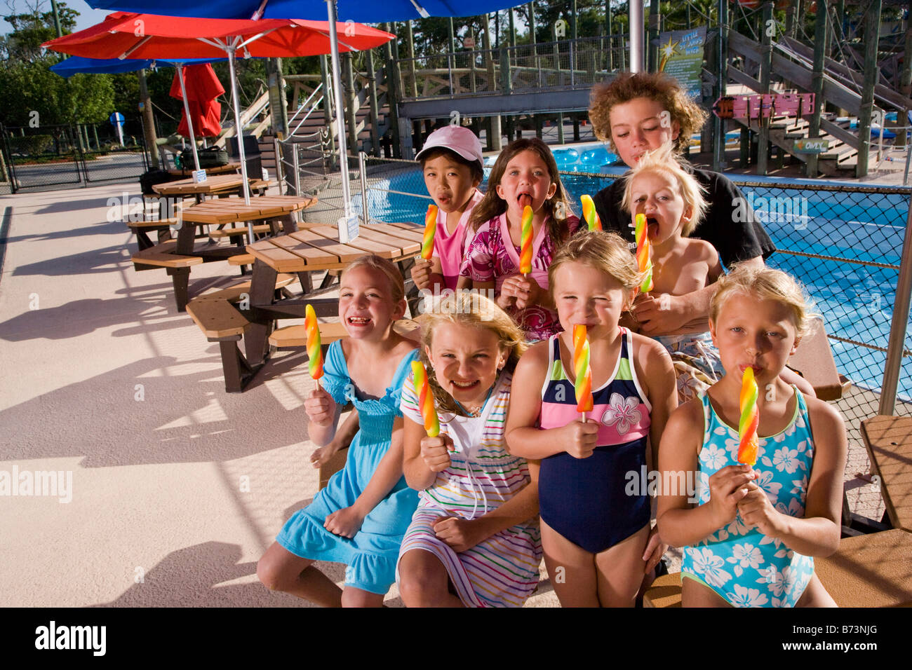 Kids eating popsicles at water park picnic table Stock Photo Alamy