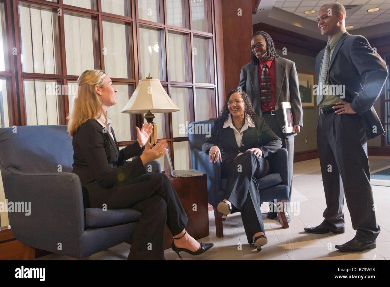 Multi-racial businesspeople having discussion in office lobby Stock Photo