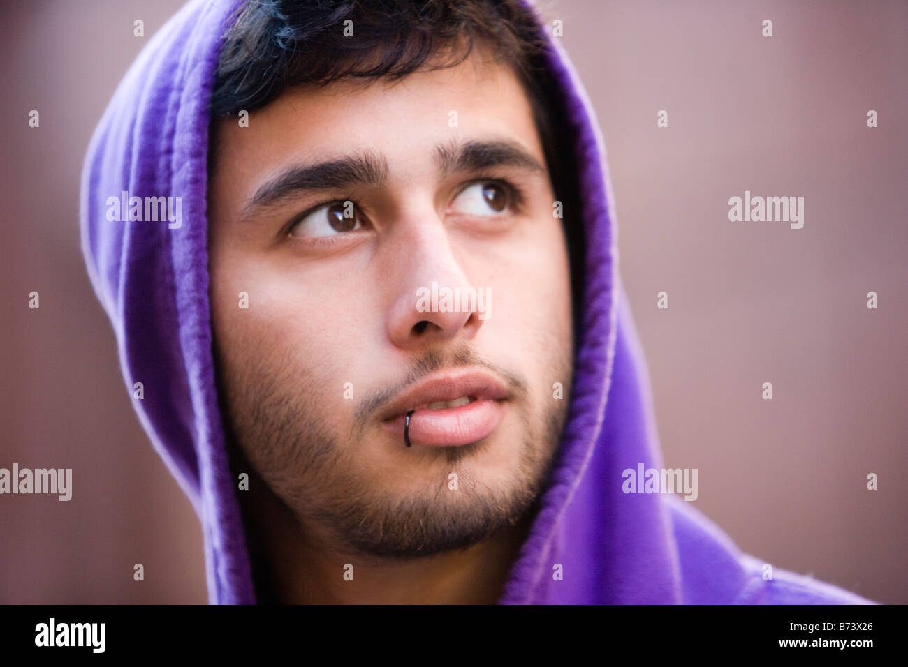 Close-up of young man with lip ring wearing hoodie Stock Photo - Alamy