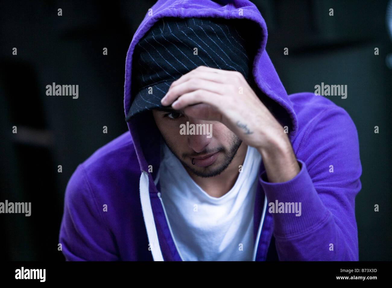 Close-up of serious young man wearing purple hoodie Stock Photo
