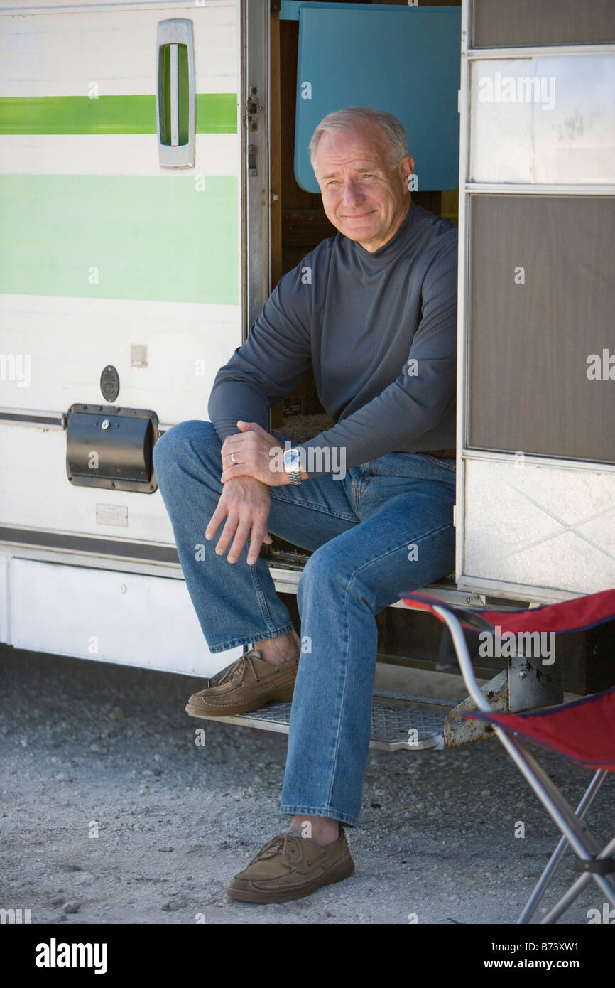 Senior man sitting in RV camper doorway, smiling Stock Photo - Alamy