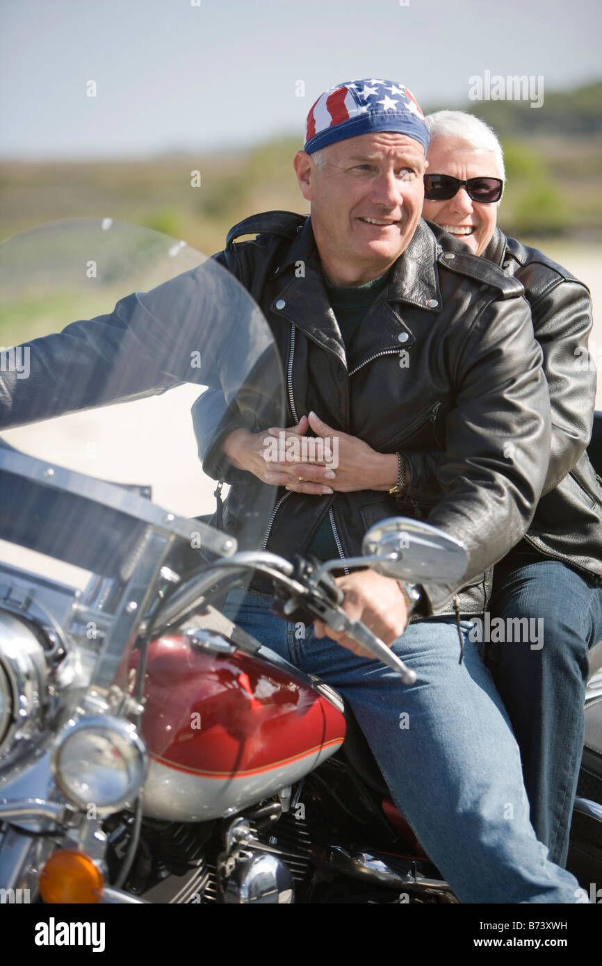 Happy senior biker couple riding motorcycle Stock Photo