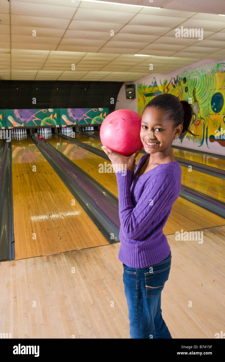 African American tween girl holding bowling ball at bowling alley Stock Photo Alamy