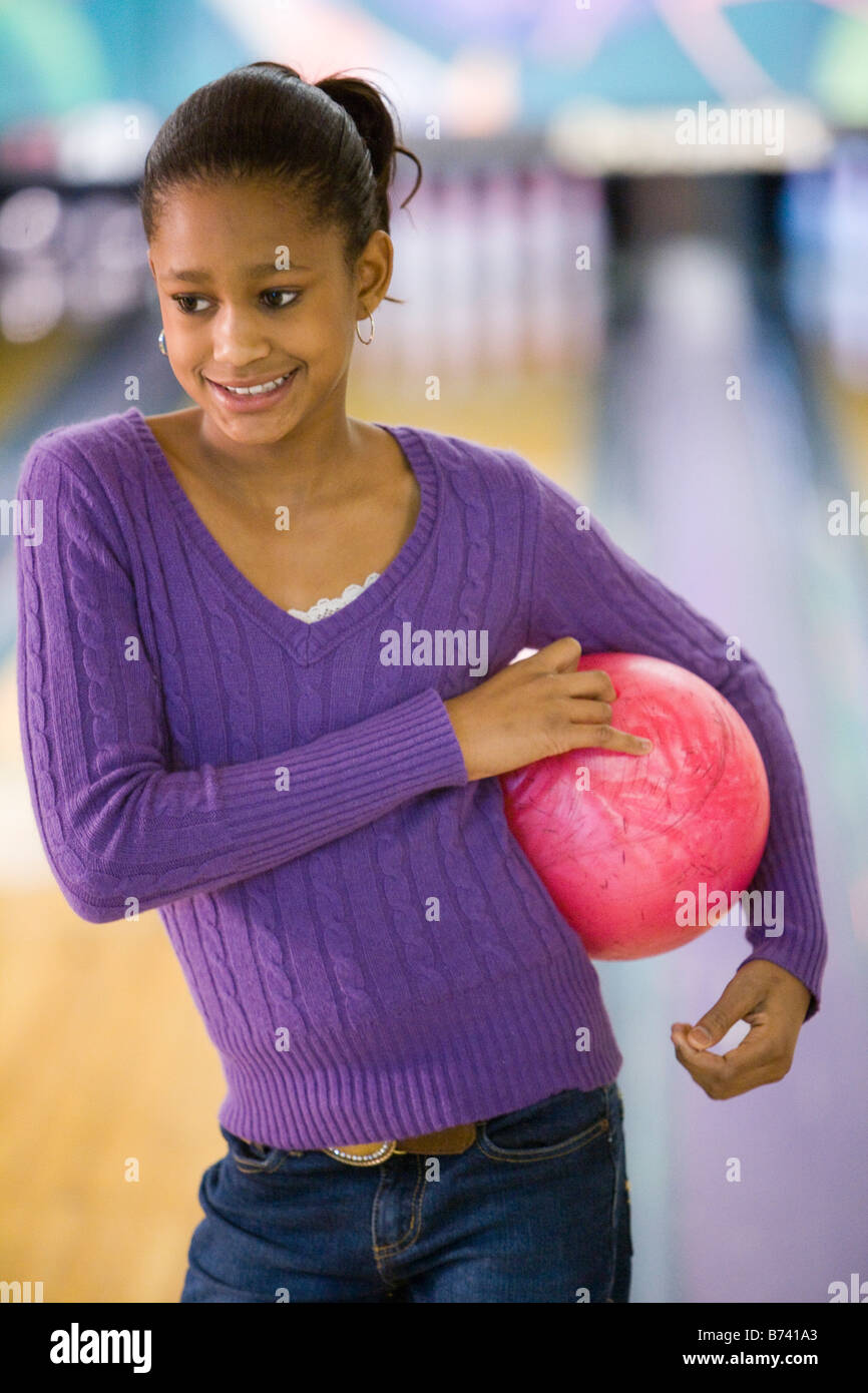 Happy African American preteen girl holding bowling ball in bowling alley Stock Photo Alamy