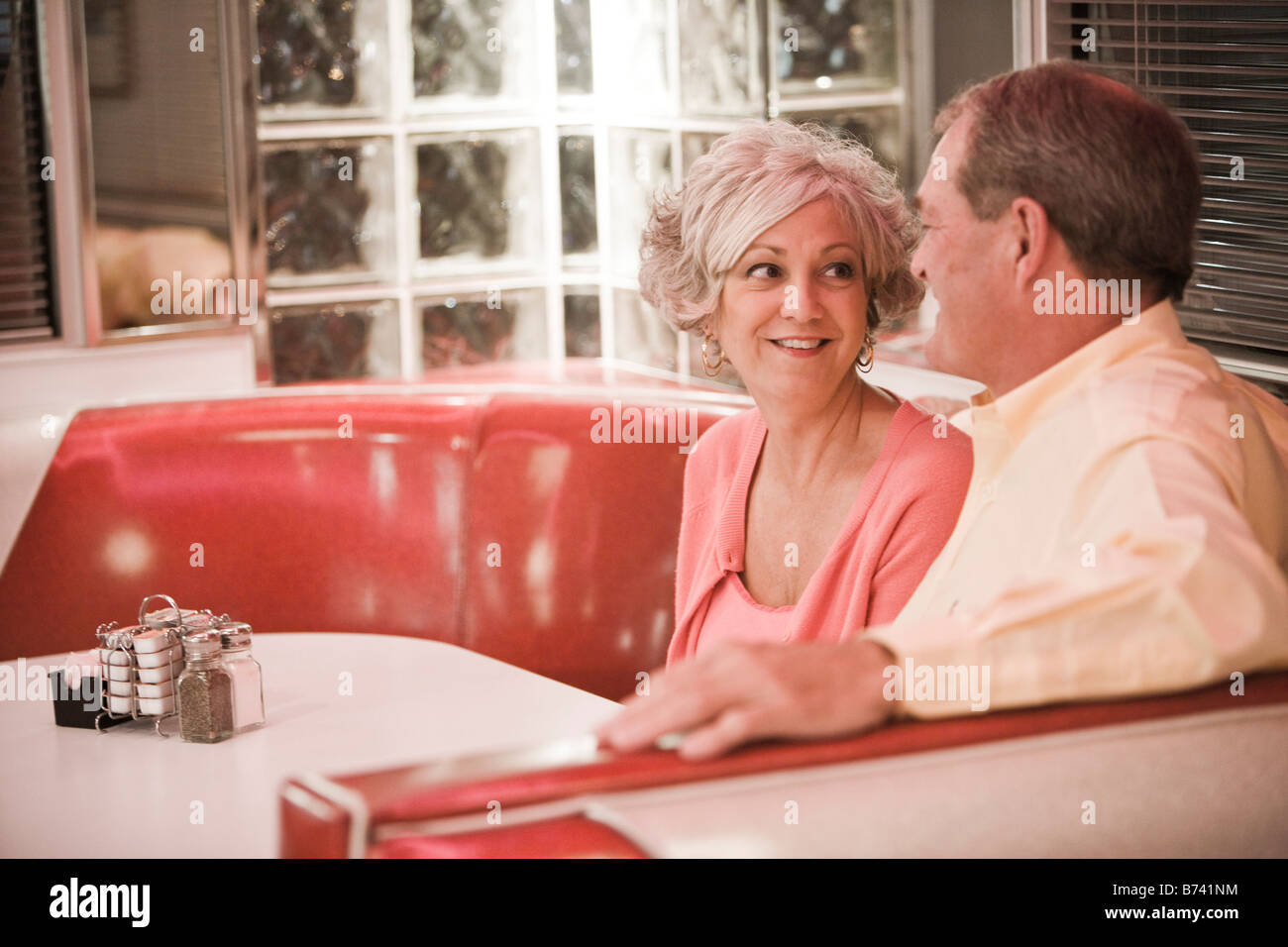 Couple sitting in restaurant booth hires stock photography and images