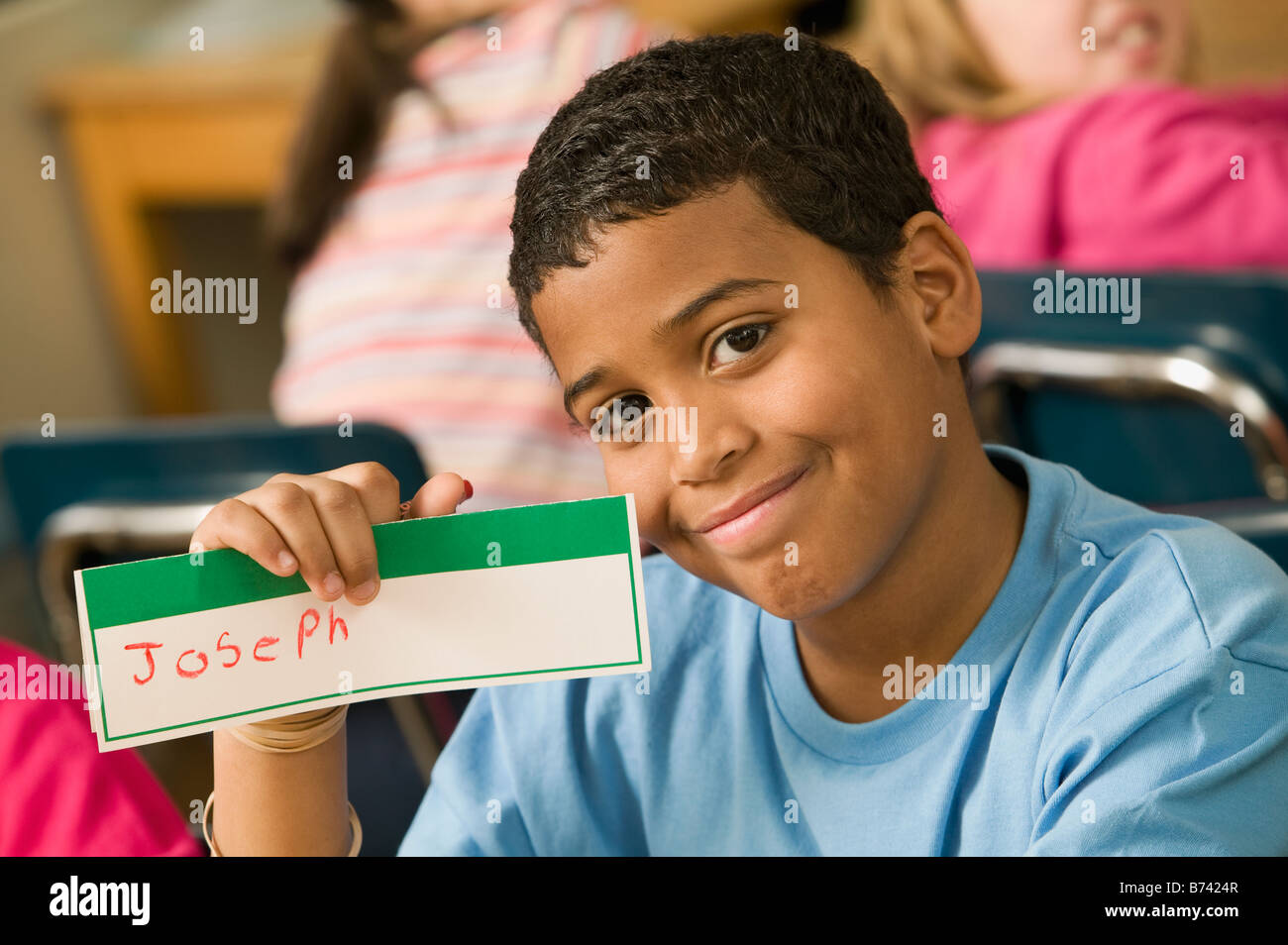 mixed-race-school-boy-holding-name-card-stock-photo-alamy