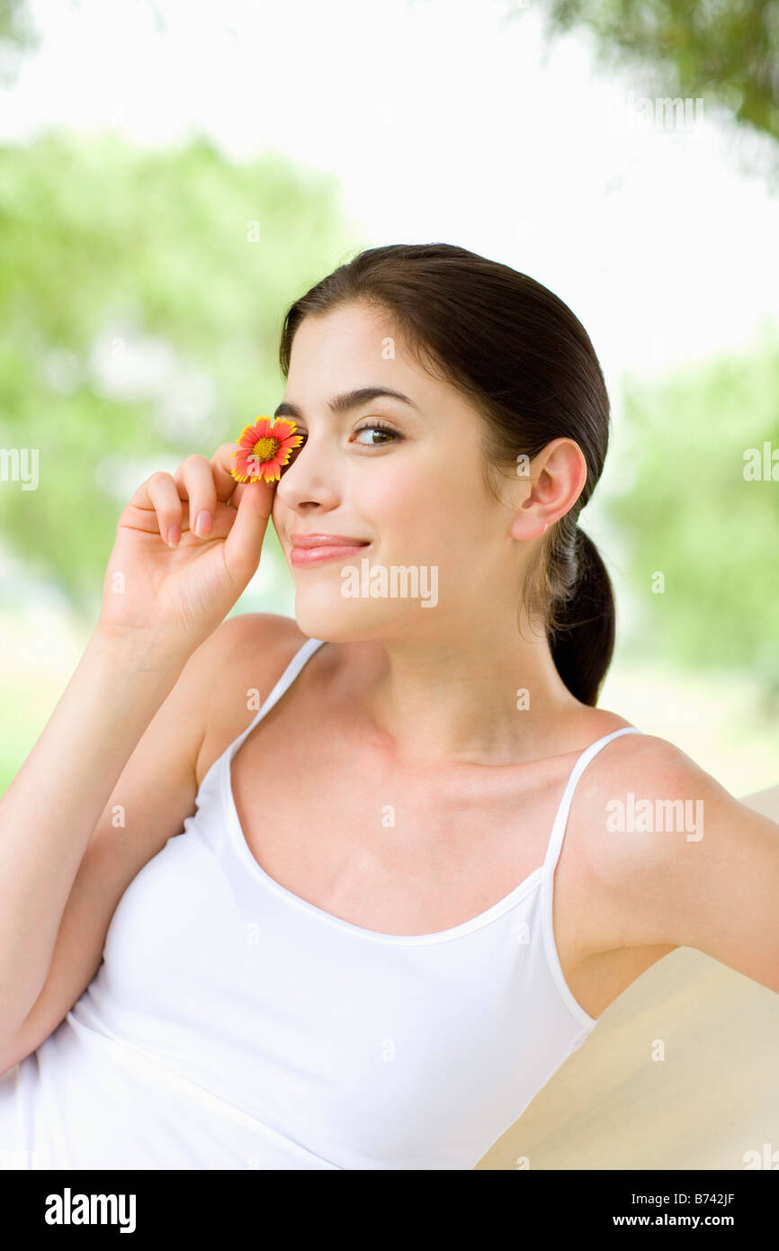 Young woman holding flower covering her eye Stock Photo Alamy