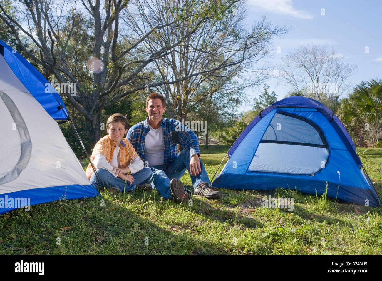 Father and son camping with tents in park Stock Photo