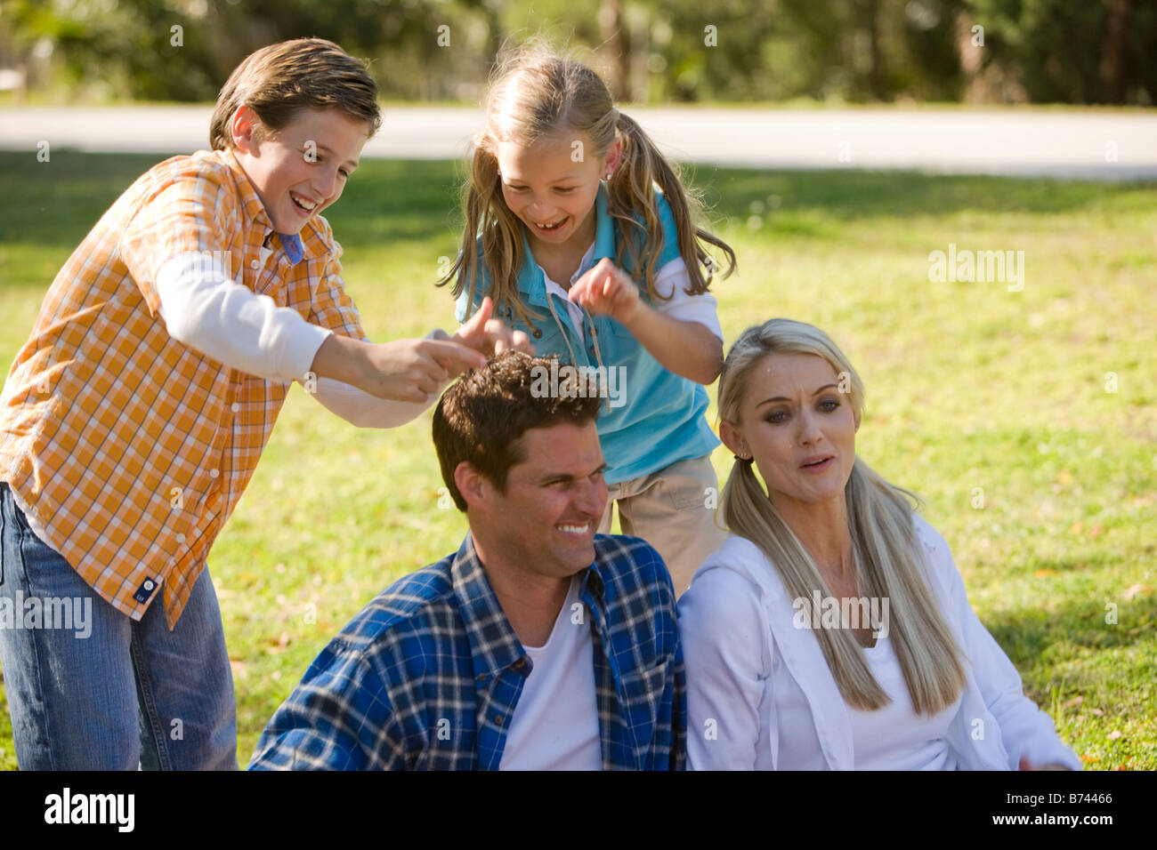 Happy family of four playing in park Stock Photo - Alamy