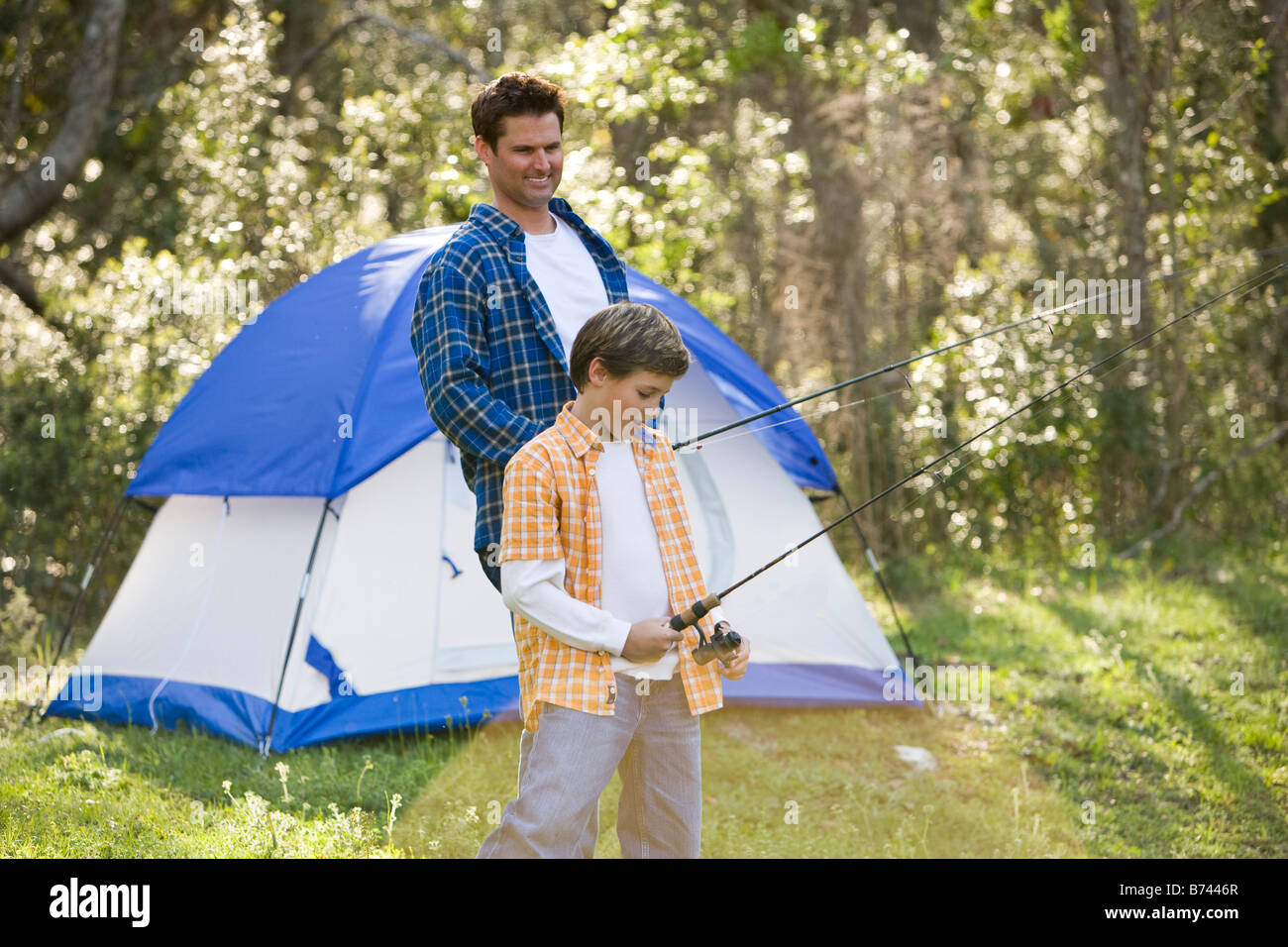 Son And Father Fishing By Tent On Camping Trip Stock Photo Alamy