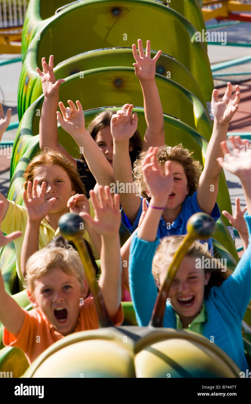 Children riding a roller coaster in an amusement park Stock Photo Alamy