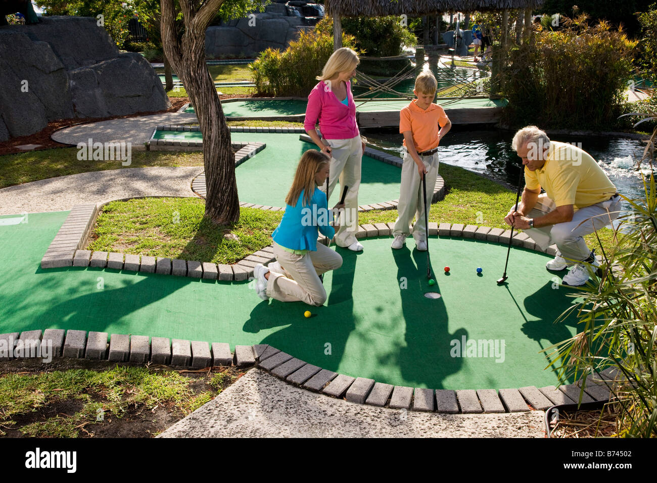 Family playing miniature golf Stock Photo - Alamy