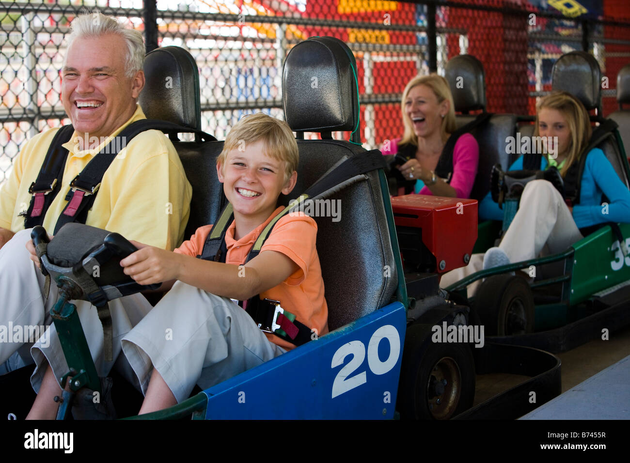 Family riding gocarts at an amusement park Stock Photo Alamy