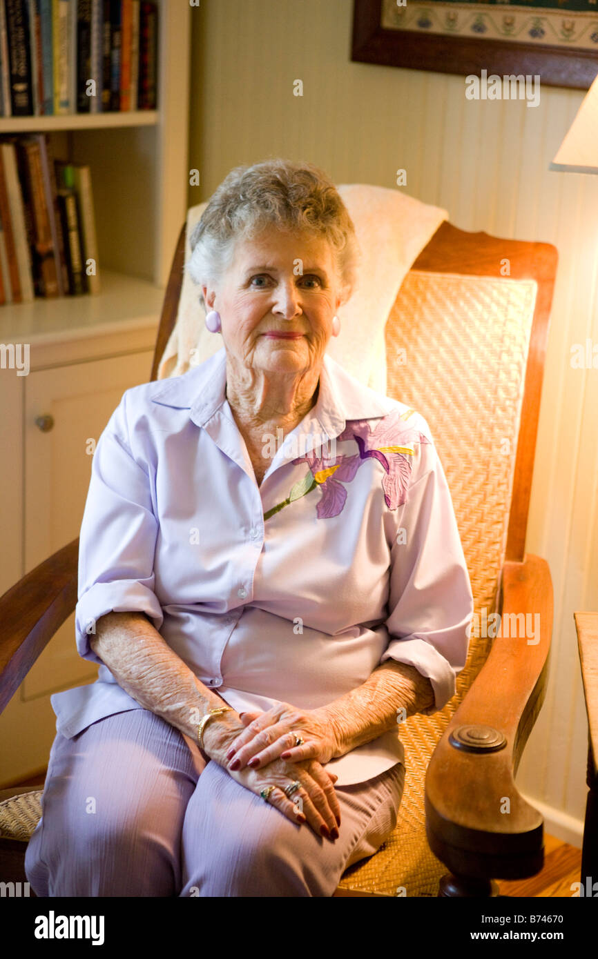 Elderly woman sitting in arm chair in house Stock Photo