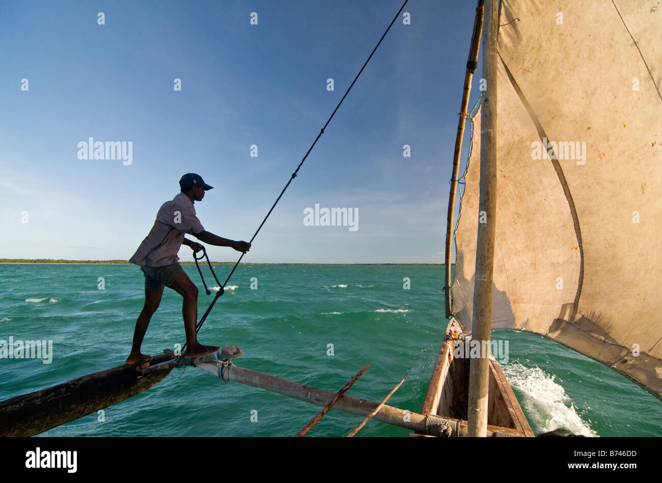 African fiisherman sailing a traditional outrigger canoe in Zanzibar, Africa Stock Photo