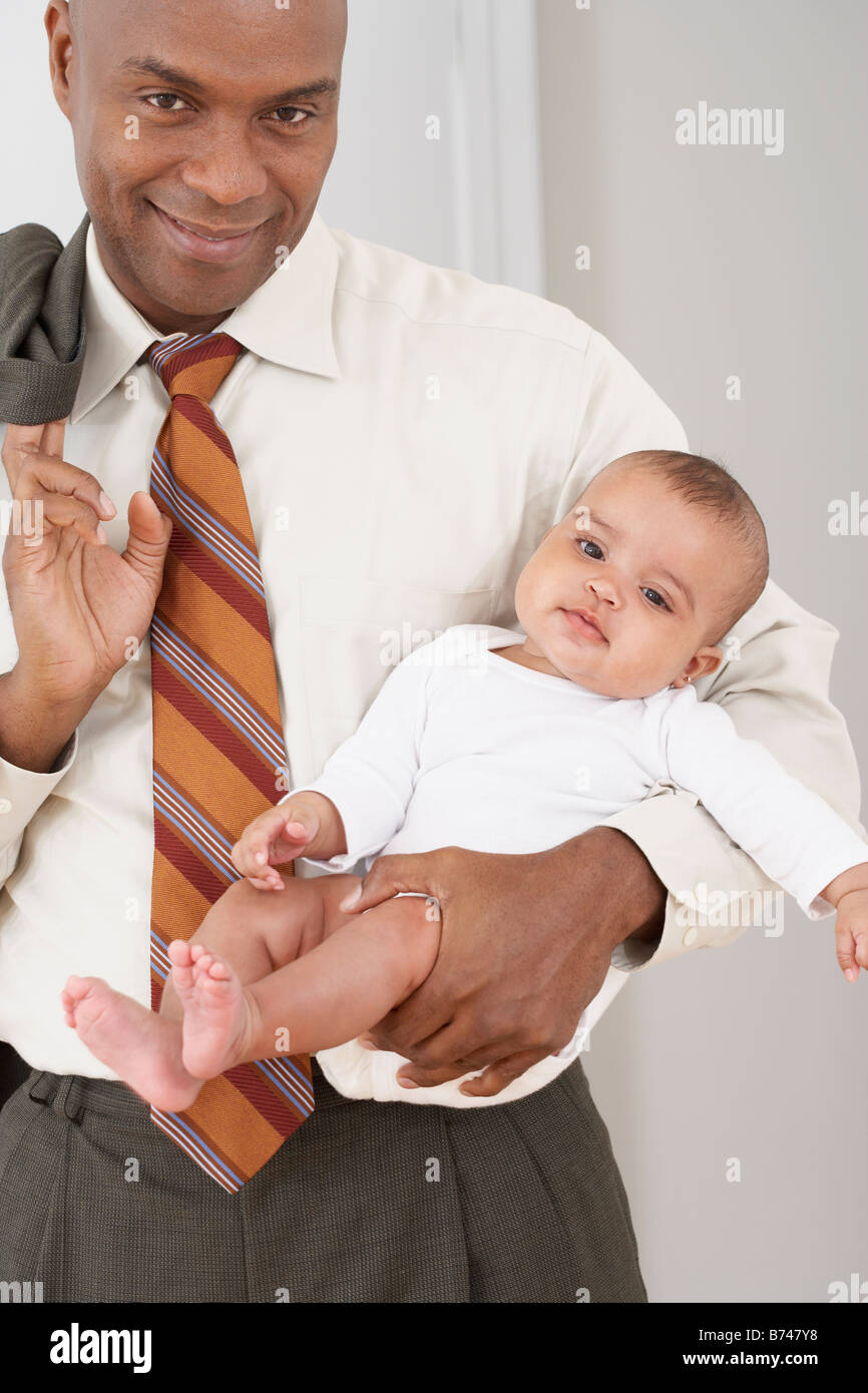 African father cradling baby daughter Stock Photo