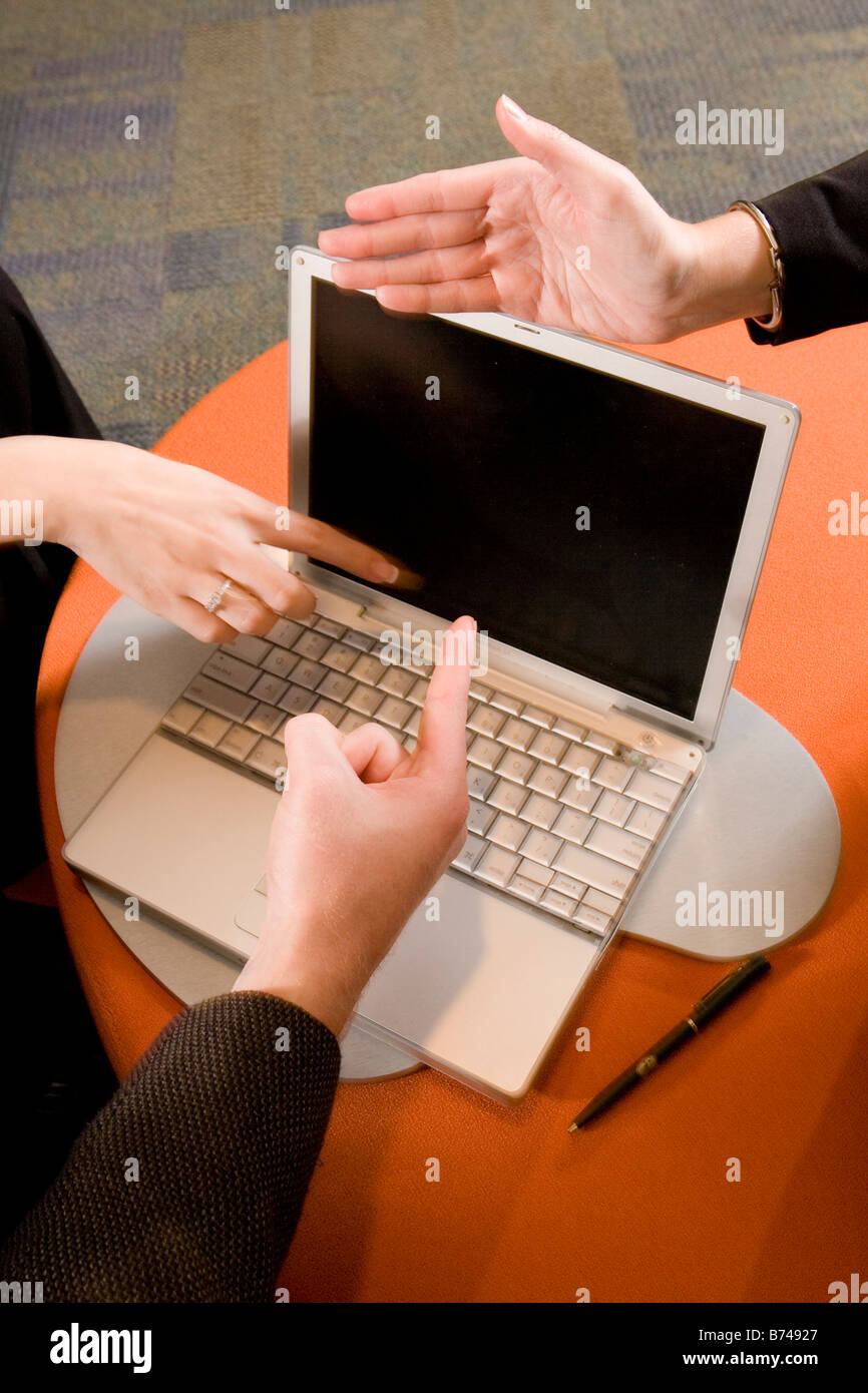 Three hands pointing to laptop screen Stock Photo - Alamy