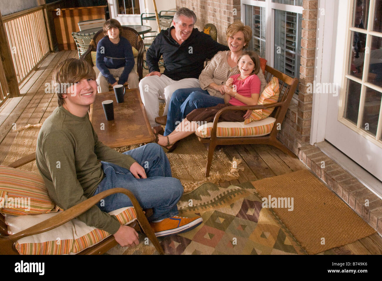 Portrait of family sitting together on porch Stock Photo - Alamy