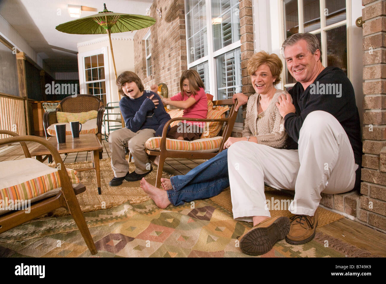 Happy family relaxing on porch hi-res stock photography and images - Alamy