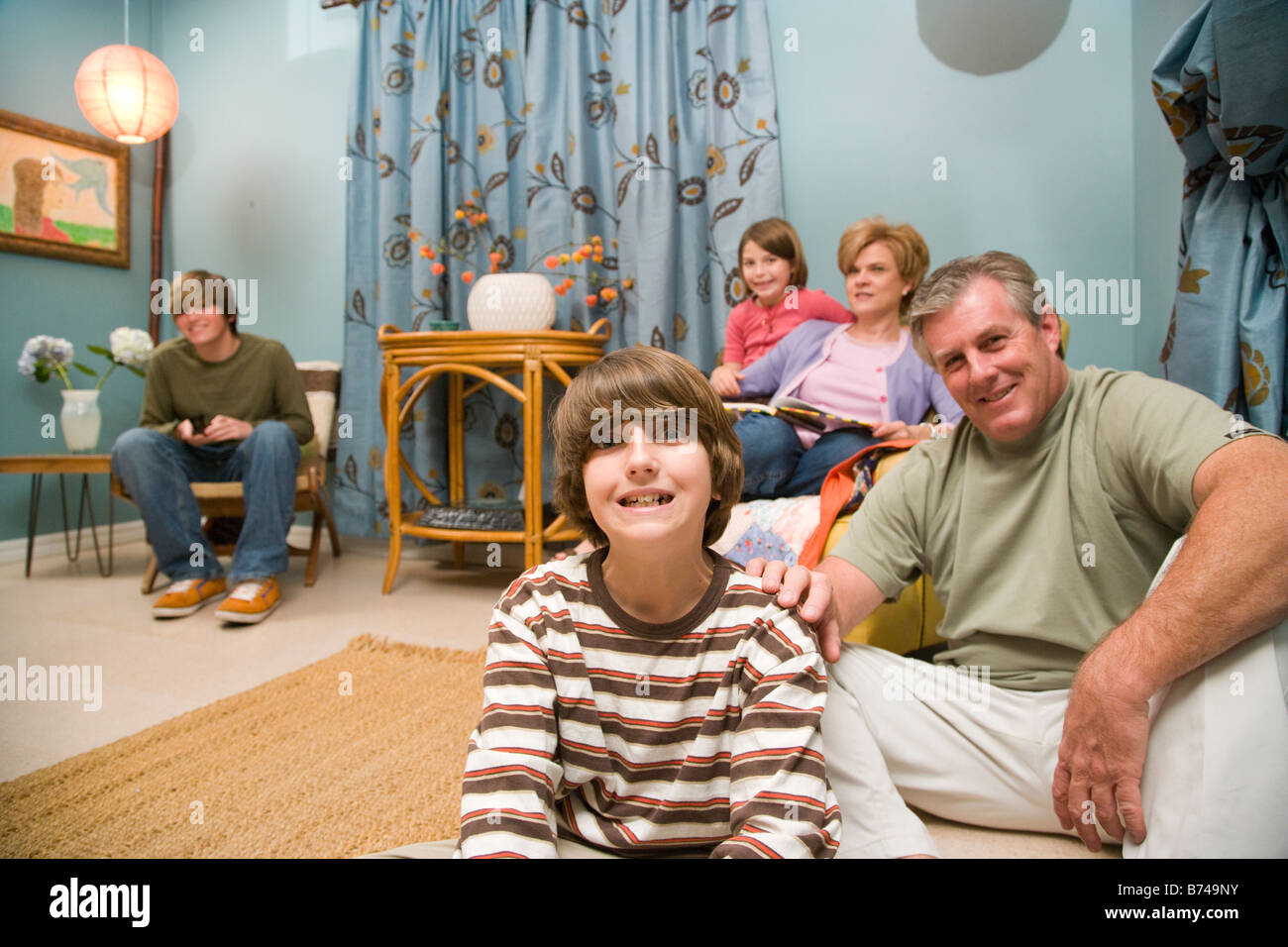 Portrait of family sitting together in living room Stock Photo