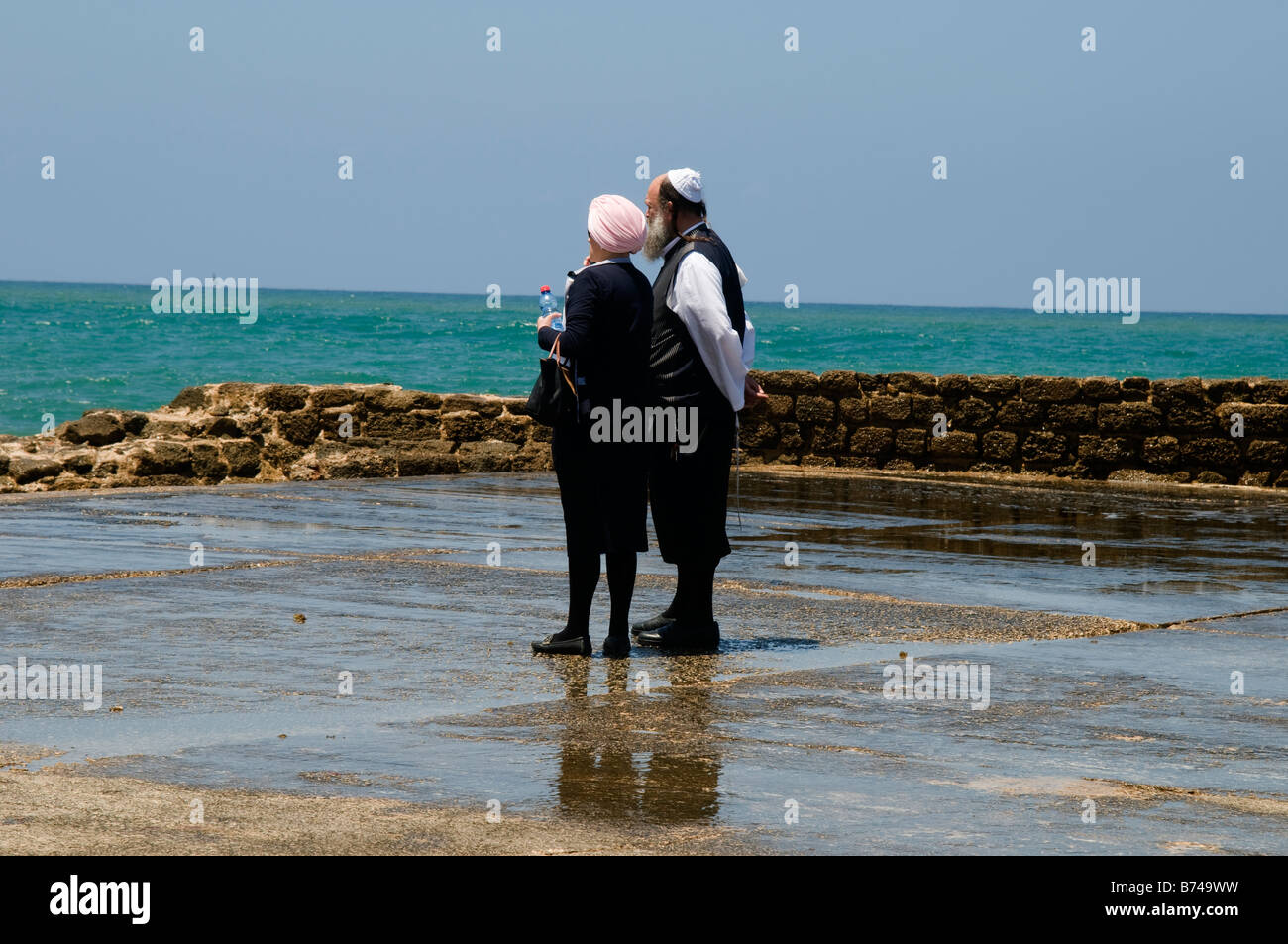 Jewish orthodox couple stay shore and watching Mediterranean Sea,Caesarea National Park,Israel Stock Photo