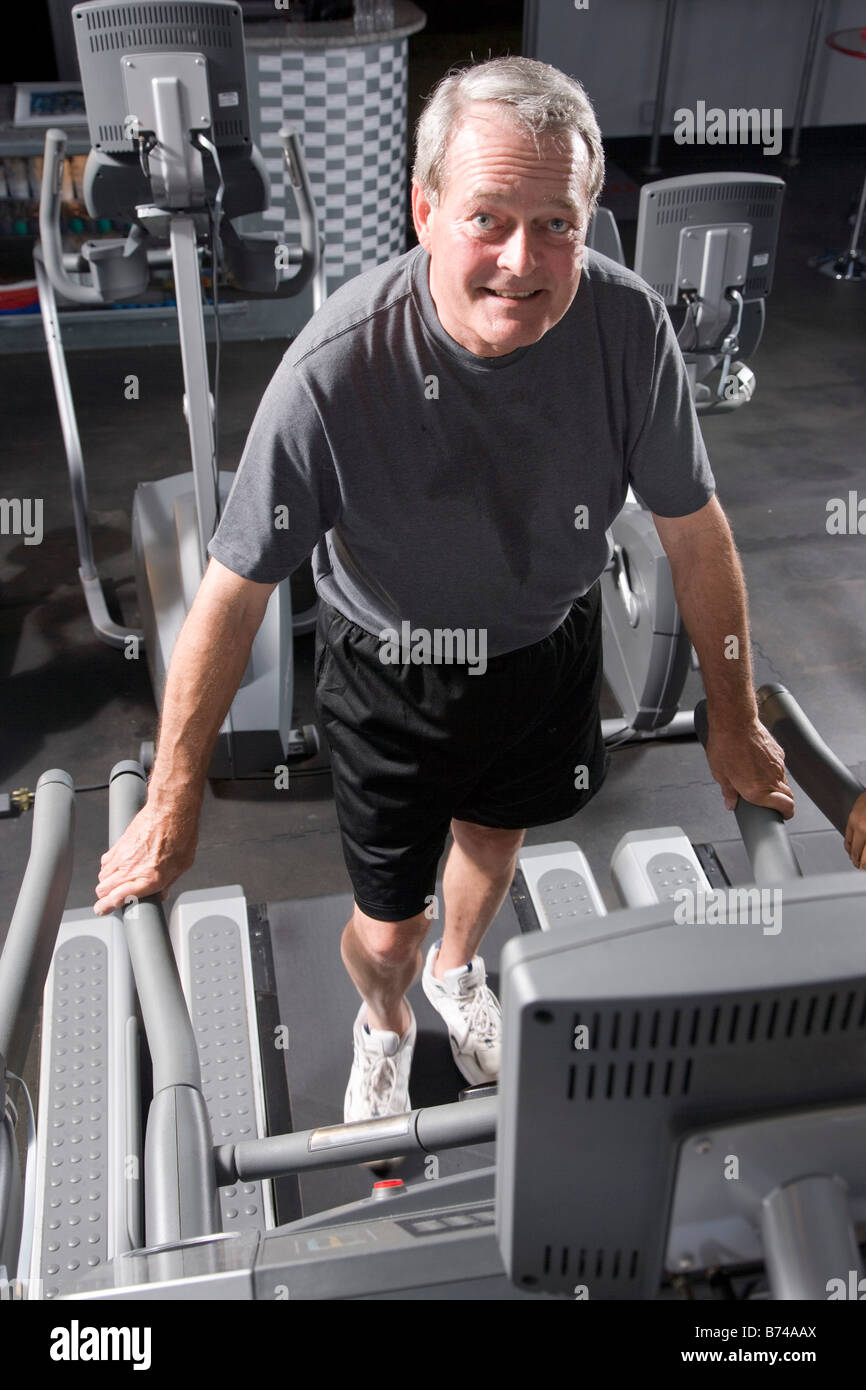 Senior man walking on treadmill at health gym Stock Photo - Alamy