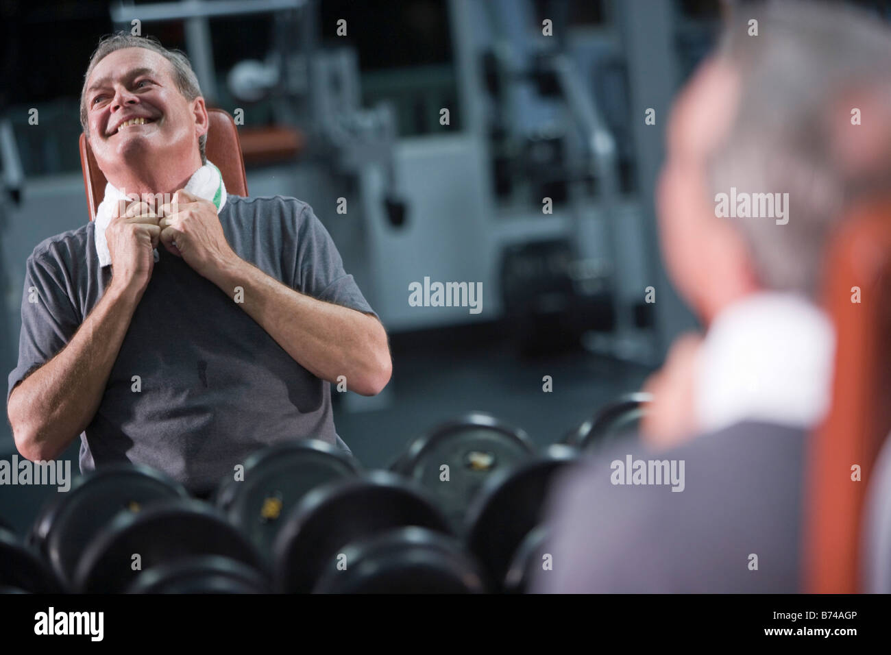 Senior man working out at gym, laughing Stock Photo