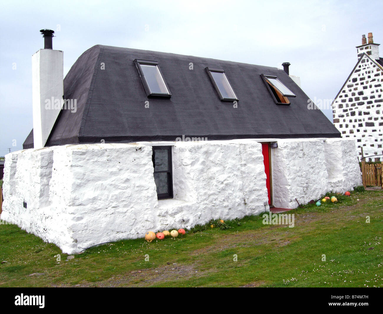 Typical modernised black house Tiree with thick walls and felt roof