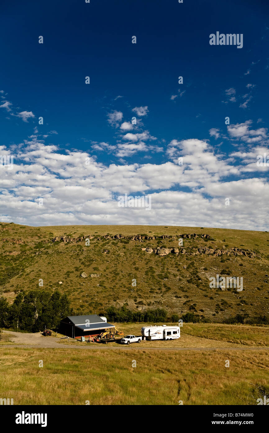 Fifth wheel trailer and truck camping beside a small barn, Montana, USA Stock Photo