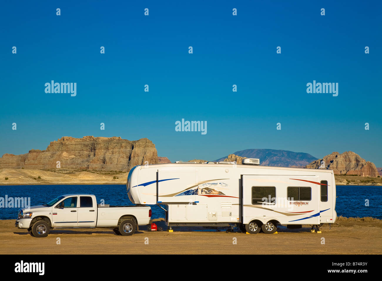 Fifth Wheel recreational vehicle and truck camped on Lone Rock Beach at Lake Powell, in the Glen Canyon National Recreation area Stock Photo