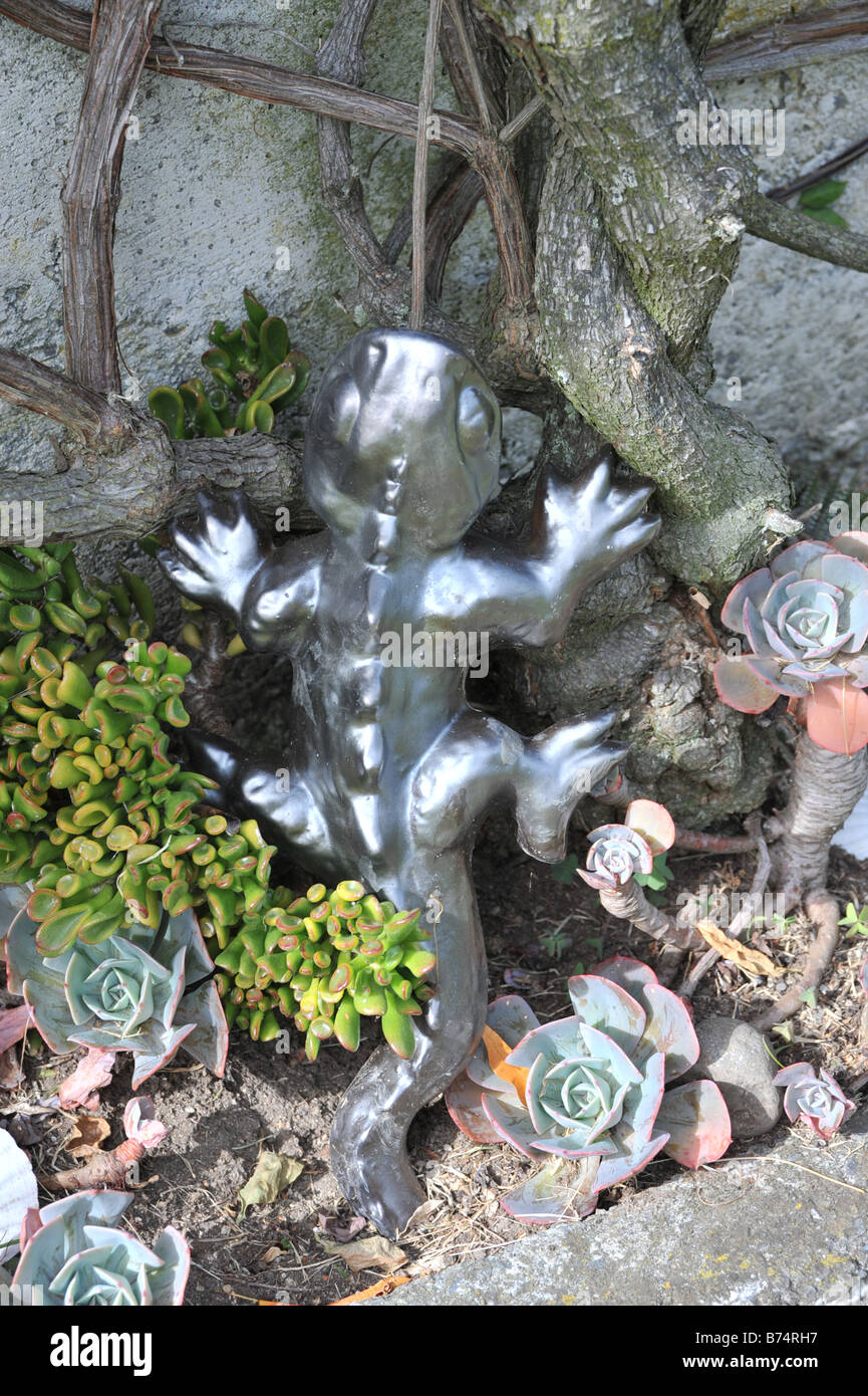 Silver gecko climbing tree against wall Stock Photo