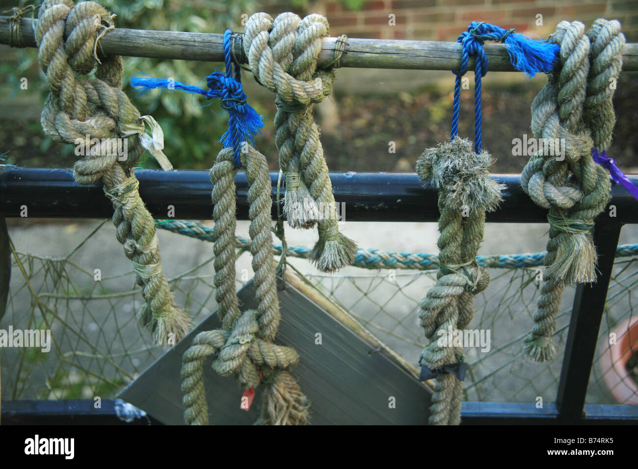 Rope with various fishermans knots on a railing Stock Photo