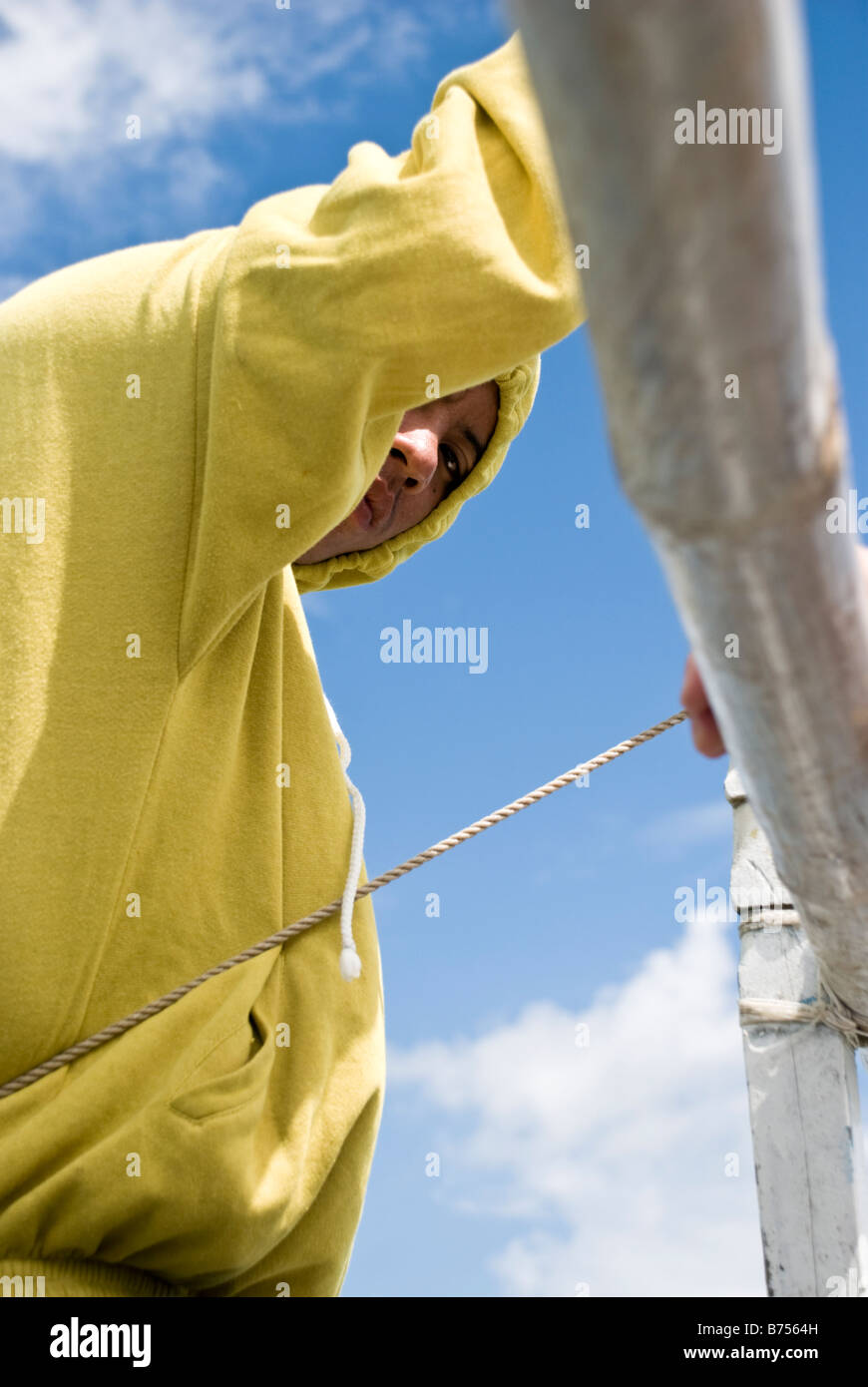 Filipino boatman looking down from his position by the mast Stock Photo