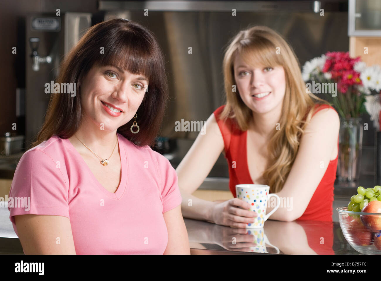 Two women seated in kitchen, Winnipeg, Canada Stock Photo