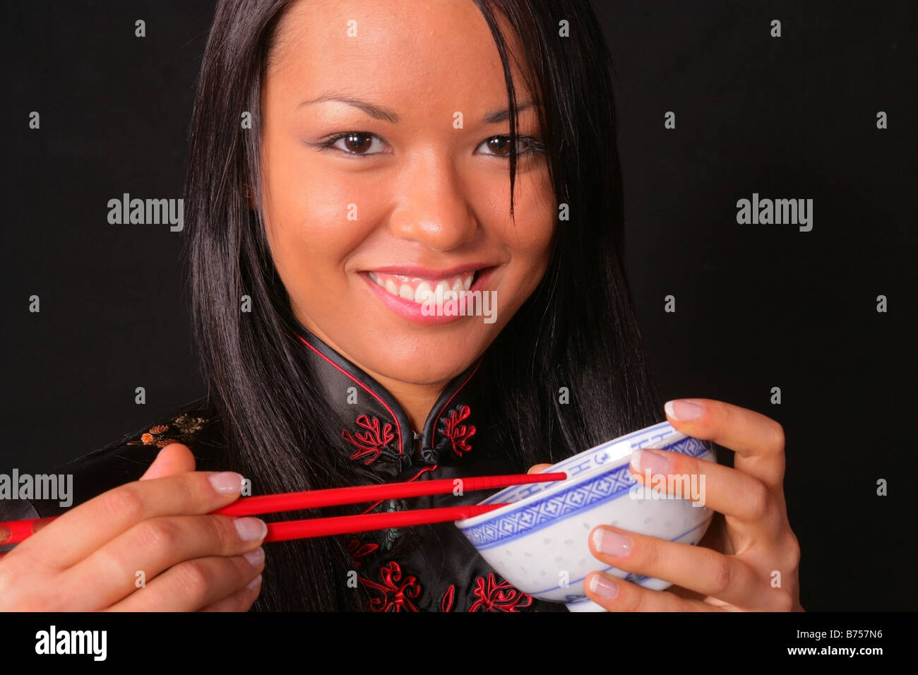 Chinese woman using chopsticks and eating chinese food Stock Photo Alamy