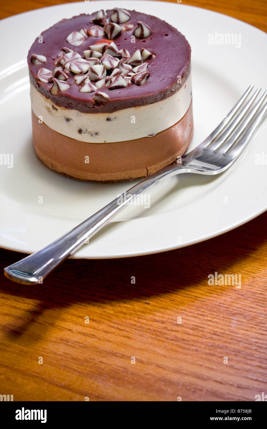 Layered chocolate cheesecake dessert on a white plate Stock Photo