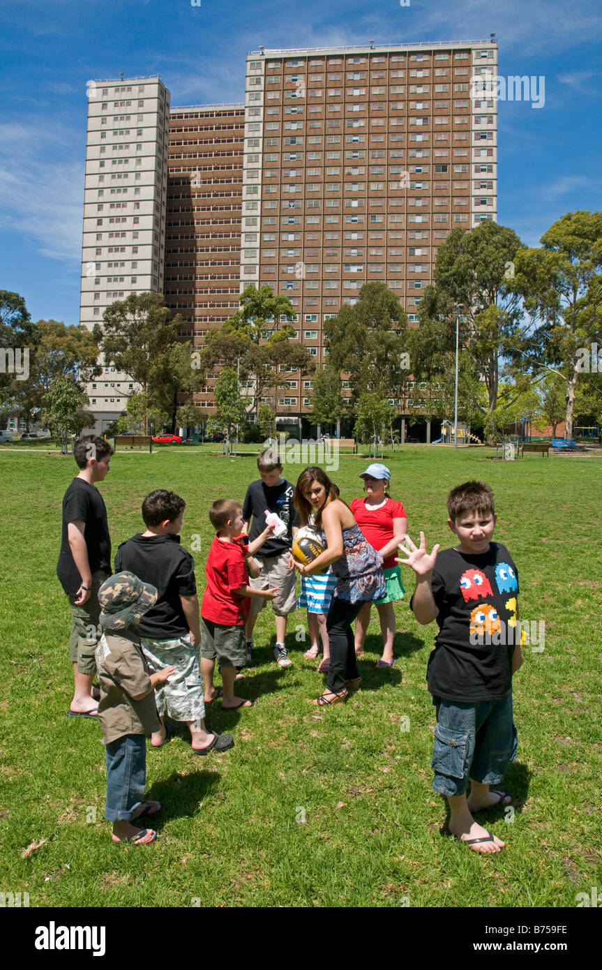 Children playing in a park near a large inner city block of Housing