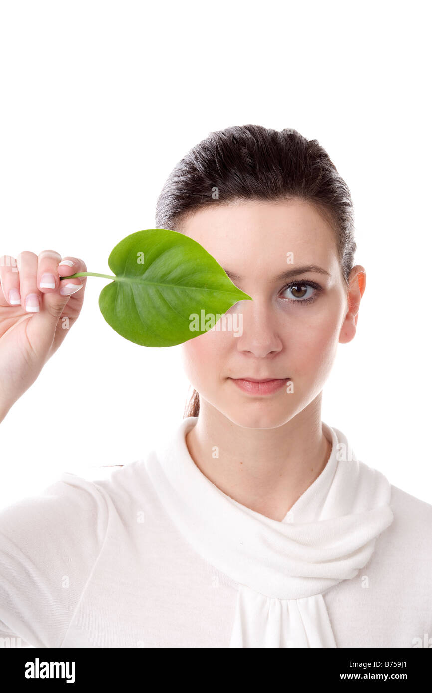 Face of a young woman with a leaf held covering one eye, Winnipeg, Manitoba Stock Photo