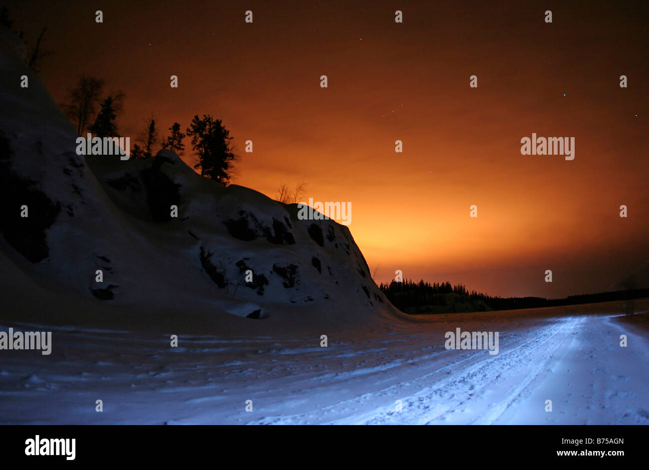 Reddish glow of the nearby city of Yellowknife in winter, Northwest Territories, Canada Stock Photo
